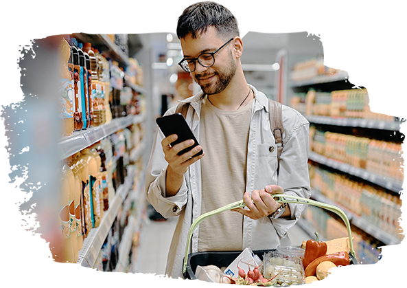 Man looking at phone while shopping for groceries